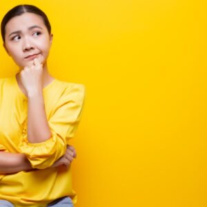 Women wondering about a question in front of a yellow wall